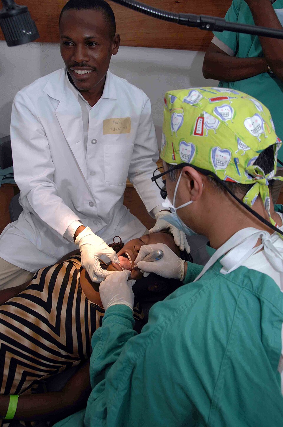 Haitian Student — US Navy 090411-N-6259S-001 A Haitian student from the University of Haiti School of Dentistry assists Cmdr. David Hartzell perform a dental procedure during a Continuing Promise 2009 medical community service event